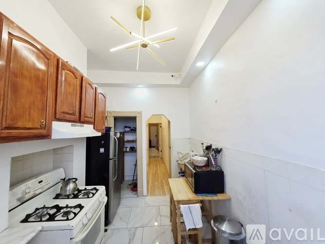 A kitchen with a white stove top oven and a black refrigerator.
