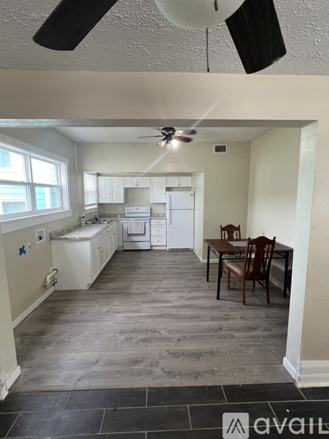 A kitchen with a dining table and chairs.