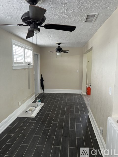 A room with a ceiling fan and tile flooring.