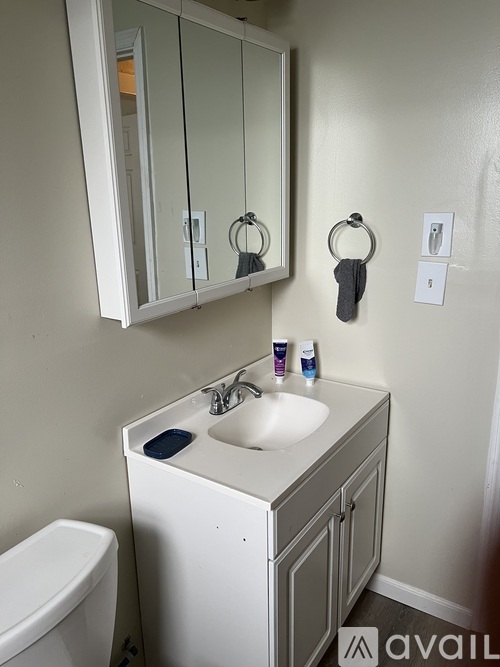 A bathroom with a sink, toilet and mirror.