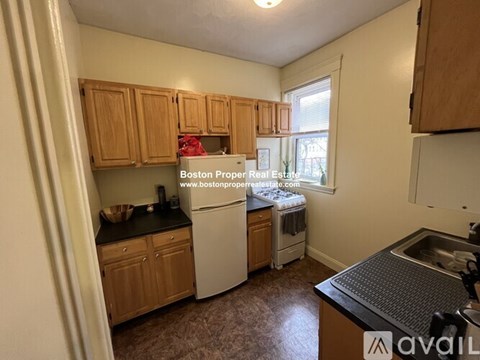 A kitchen with wooden cabinets and a white refrigerator.