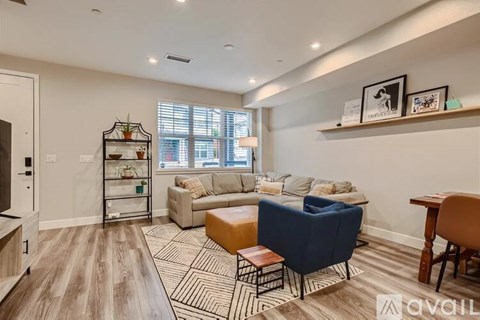A living room with a blue chair and a wooden table.