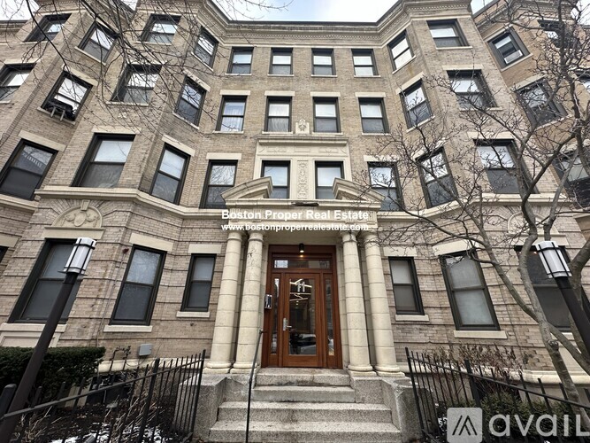 A large, multi-story building with a central entrance and a balcony above the doorway.