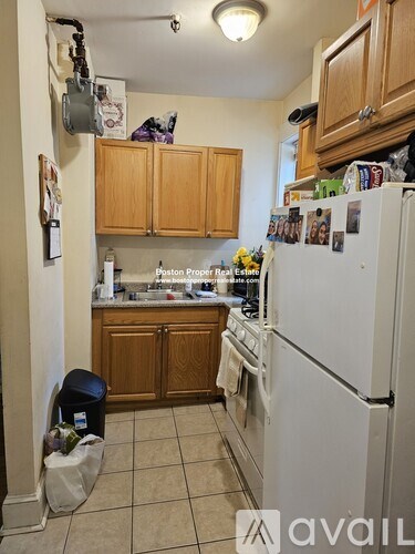 A kitchen with a white fridge and wooden cabinets.