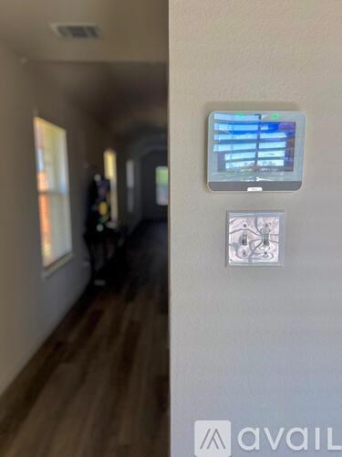 A wall-mounted security camera overlooks a hallway.