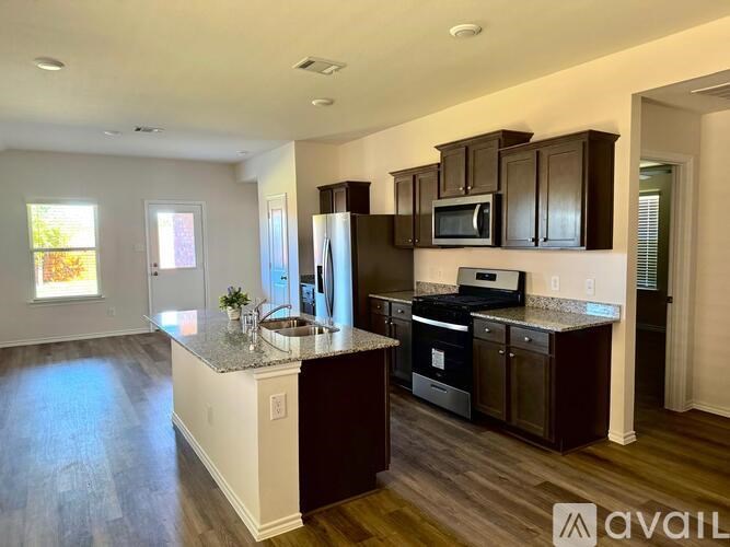 A kitchen with dark brown cabinets and a white island.