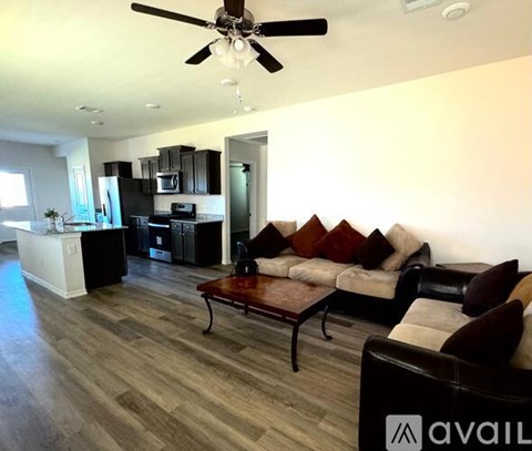A modern living room with a black couch and a wooden coffee table.