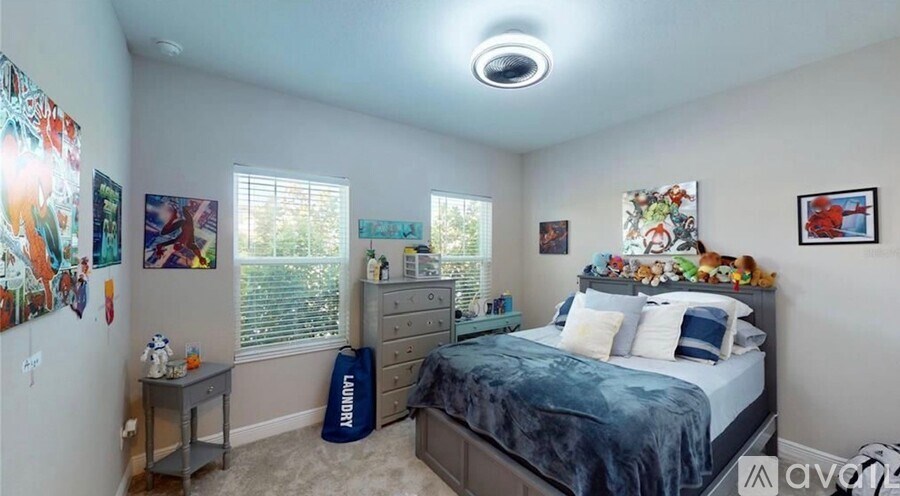 A bedroom with a bed, dresser, and a window with blinds.