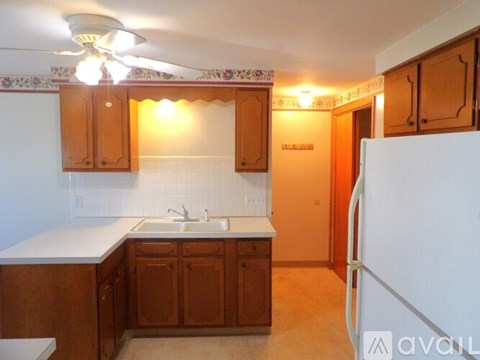 A kitchen with wooden cabinets and a white countertop.