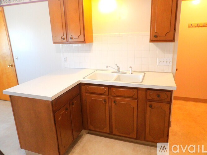A kitchen with wooden cabinets and a white countertop.