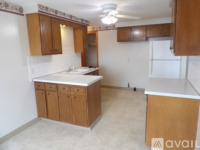 A kitchen with wooden cabinets and a white countertop.