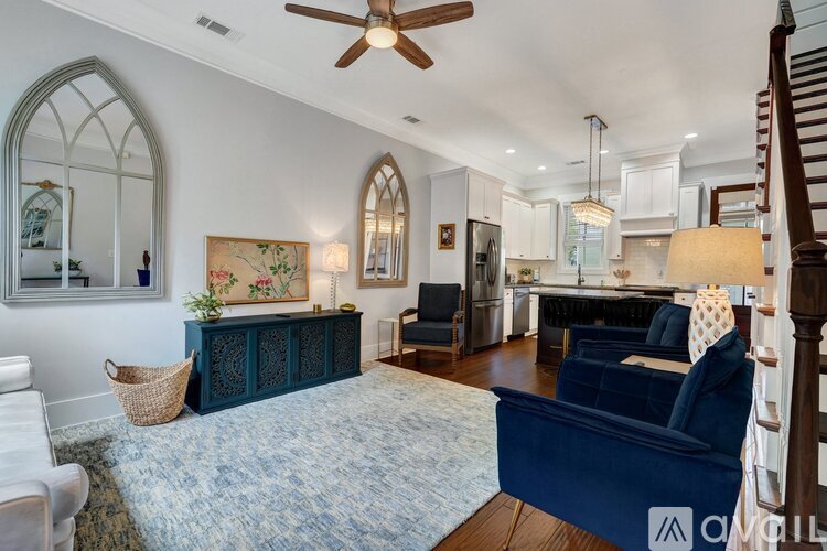 A living room with a blue sofa and a fan.