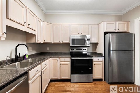 A kitchen with wooden cabinets and a black fridge.