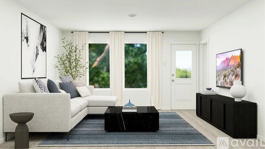 A modern living room with a grey sofa, a black coffee table, and a large window with curtains.
