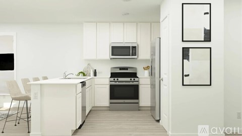 A modern kitchen with white cabinets and a wooden floor.