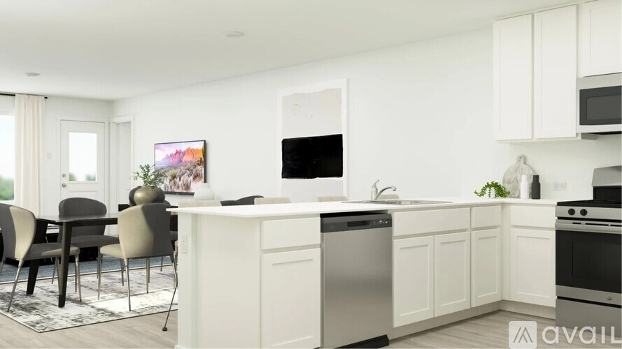 A modern kitchen with white cabinets and stainless steel appliances.