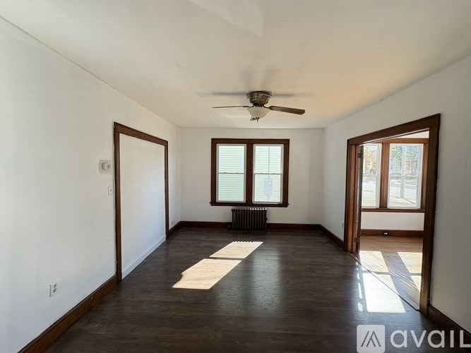 A room with a ceiling fan and a window with blinds.