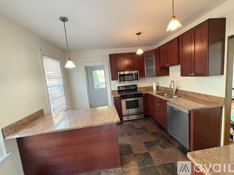 A kitchen with brown cabinets and a checkered floor.