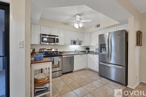 A kitchen with white cabinets and stainless steel appliances.