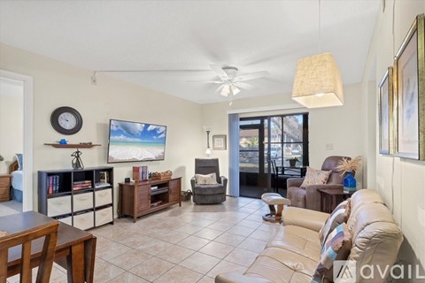 A living room with a white couch and a flat screen TV.
