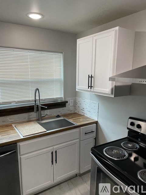 A kitchen with white cabinets and a black stove top.