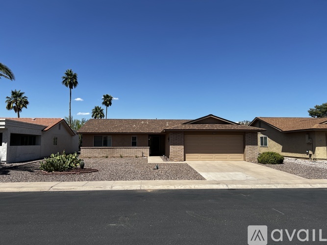 A house with a brown roof and a driveway in front.