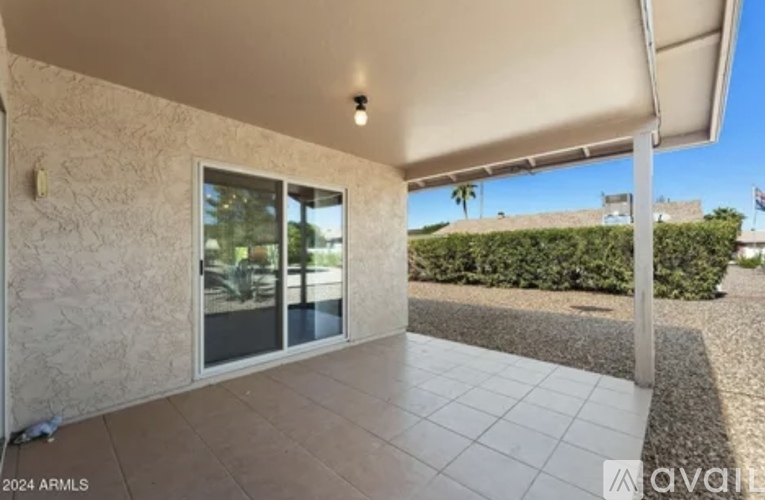 A patio area with a sliding glass door and a white awning.