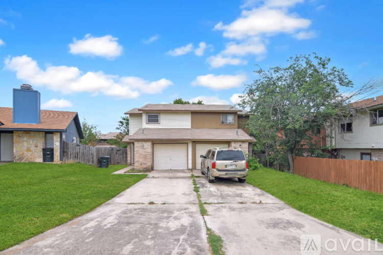 A two-story house with a garage and a car parked in front.
