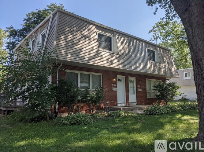 A house with a red brick exterior is for sale.