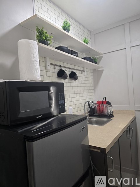 A black microwave oven is on a black dishwasher in a kitchen.