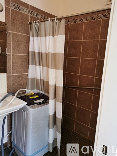 A shower curtain with a striped pattern hangs in a bathroom.