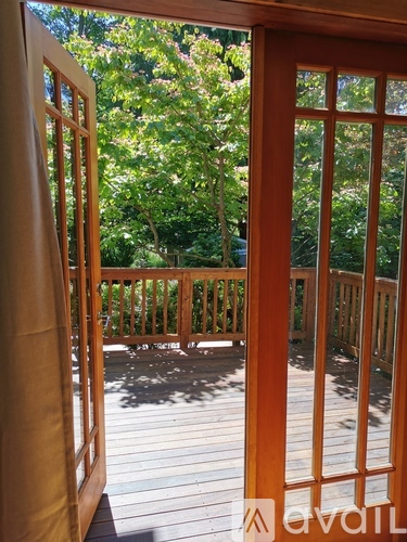 A deck with a railing and trees in the background.