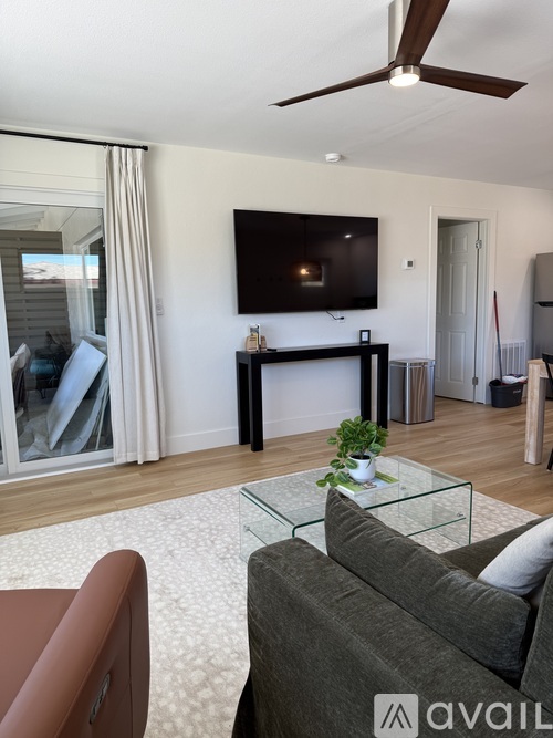 A living room with a grey couch and a glass coffee table.