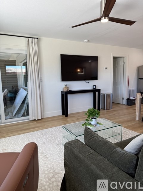 A living room with a grey couch and a glass coffee table.