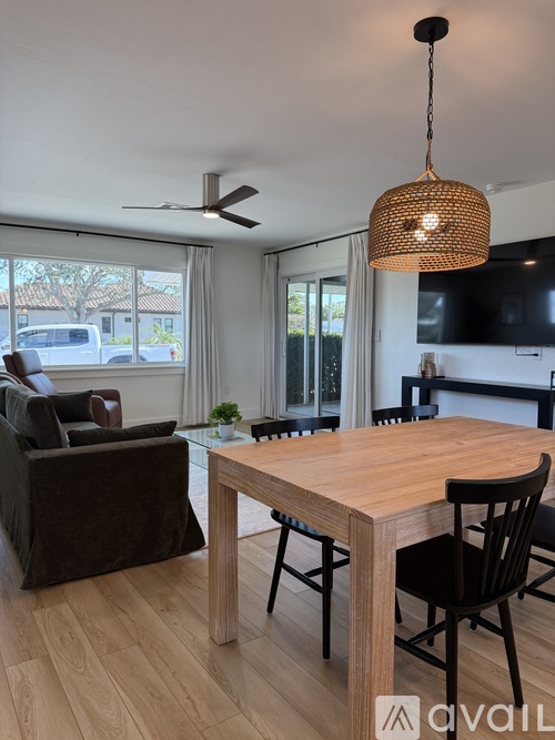 A modern dining room with a wooden table and chairs.