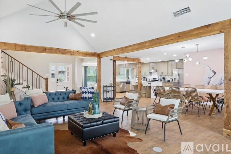 A living room with a blue couch and a wooden floor.