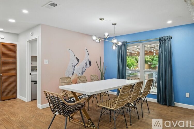 A dining room with a white table and chairs.