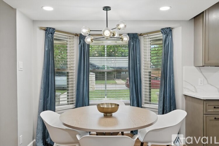 A dining room with a round table and chairs.