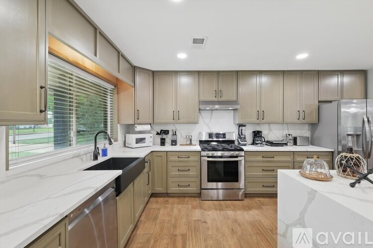 A kitchen with wooden cabinets and a marble countertop.