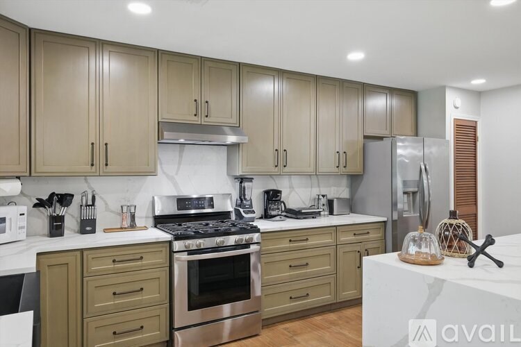 A kitchen with a white countertop and wooden cabinets.