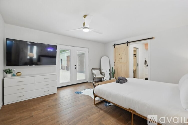 A bedroom with a bed, chair, and a television.