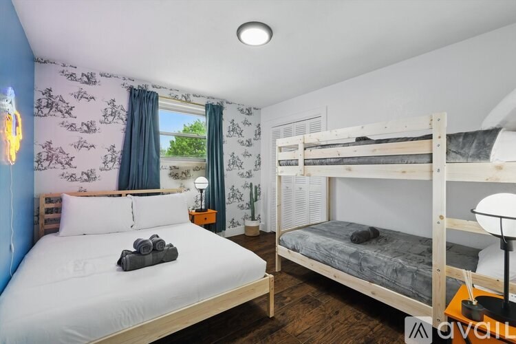 A bedroom with two beds and a window with curtains.