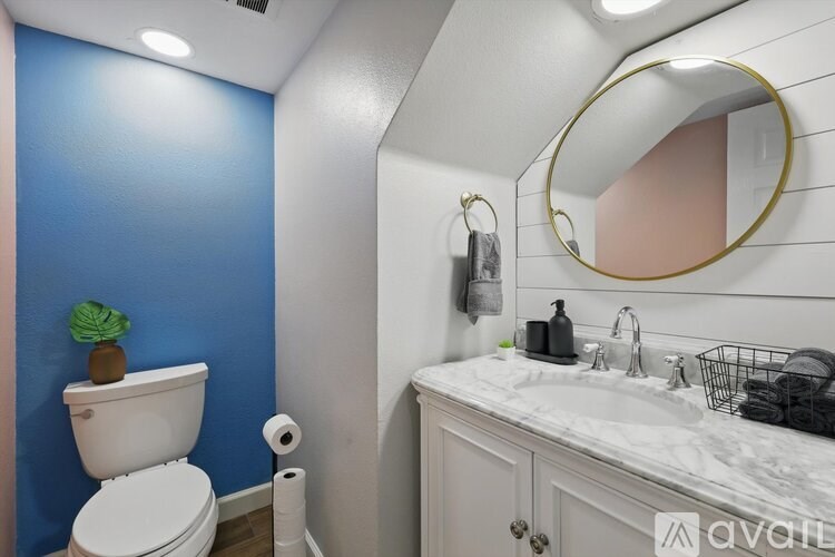 A bathroom with blue walls and a white toilet.