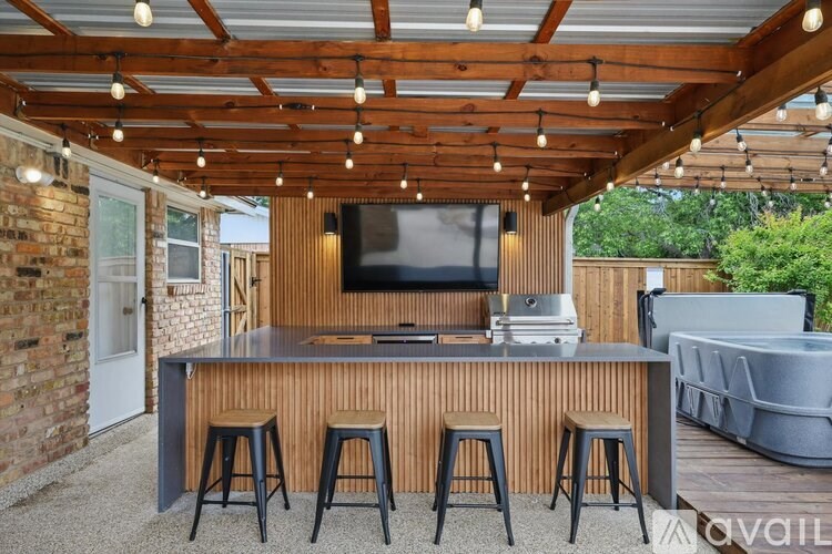 A wooden bar with stools under a roof with lights.