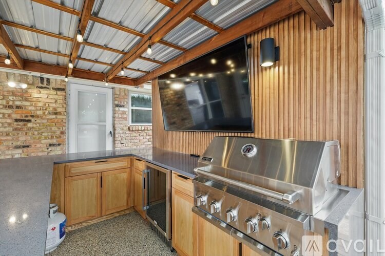 A modern kitchen with wooden cabinets and a stainless steel grill.