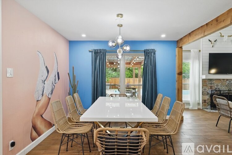 A dining room with a large table and chairs.
