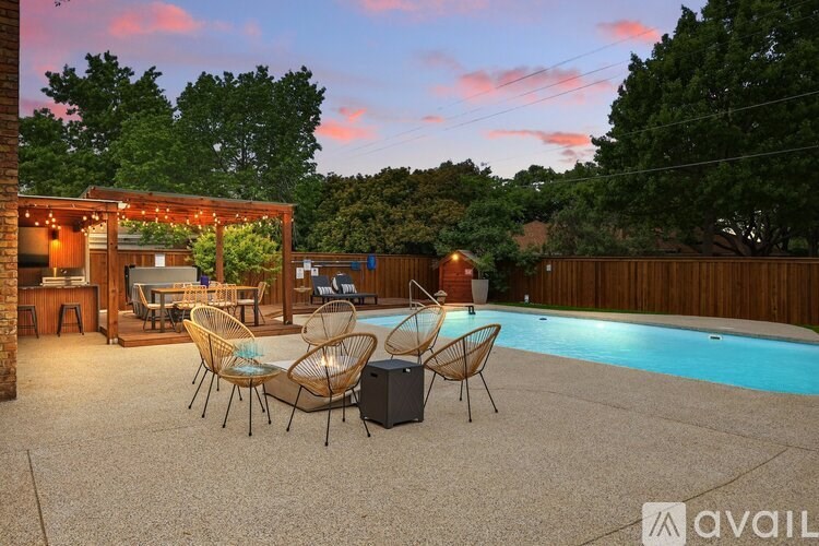 A backyard with a pool and patio furniture.
