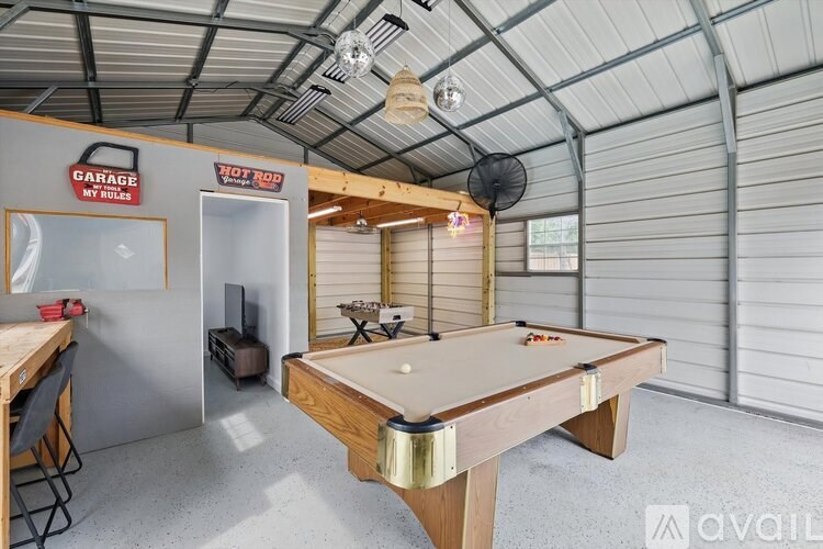 A pool table in a room with a sign that says "GARAGE MY RULES".