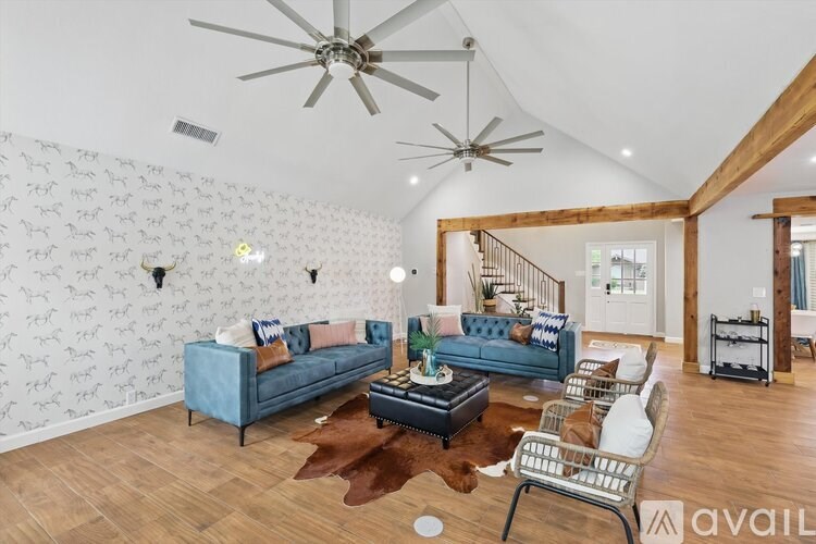 A living room with a blue couch and a wooden floor.