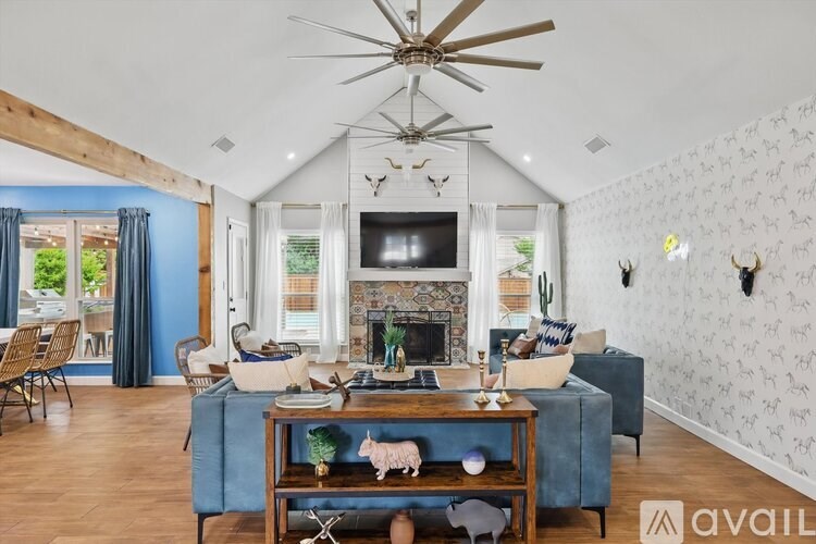 A living room with a fireplace, a television, and a blue couch.